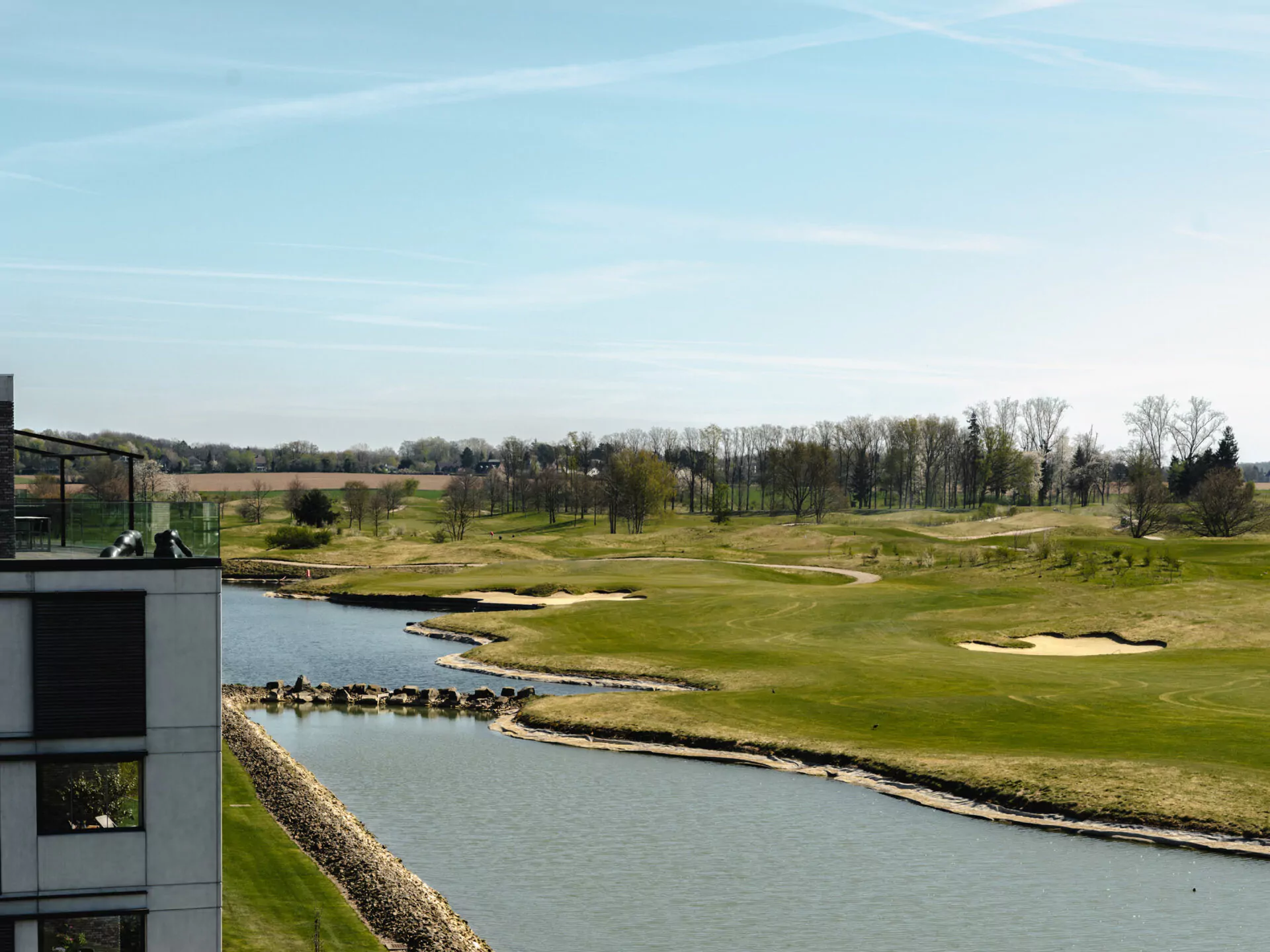 Panoramisch uitzicht op de golfbaan van Sterrebeek vanuit een modern appartement met terras