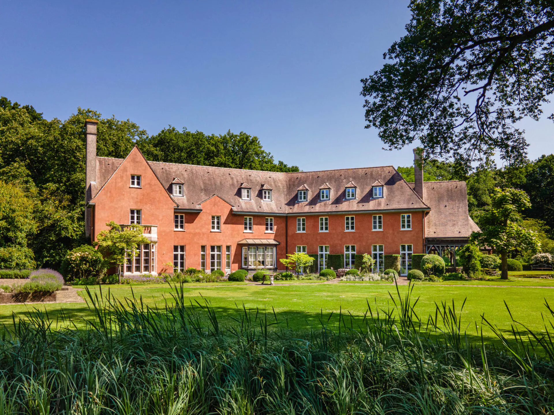 Maison rouge à Forest Bruxelles avec grand jardin et façade traditionnelle, parfaite pour vente immobilière 2025